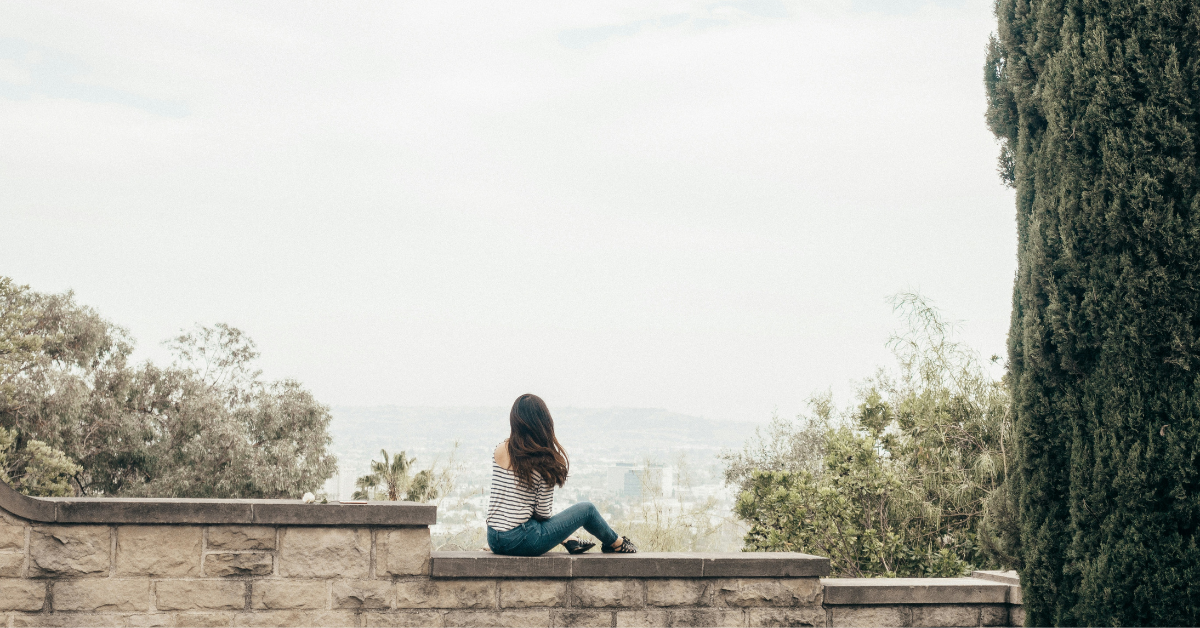 woman sitting on a brick wall