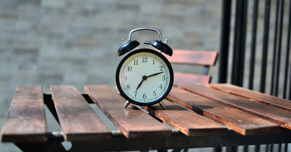 Black alarm clock on a wooden outdoor table