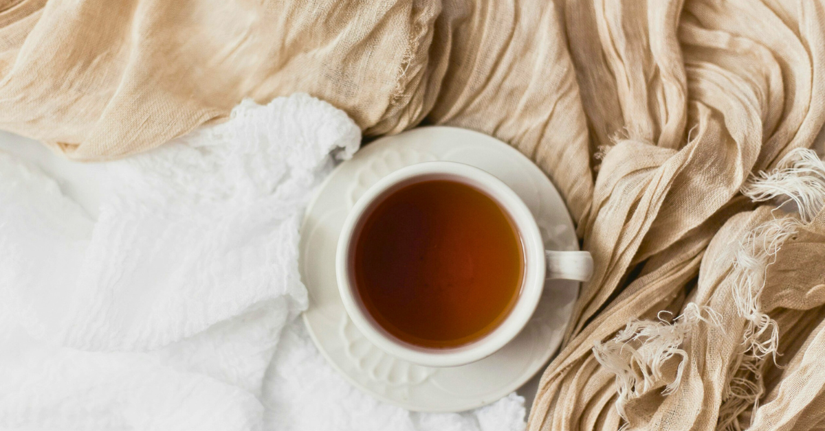 A cup of tea sitting on blankets